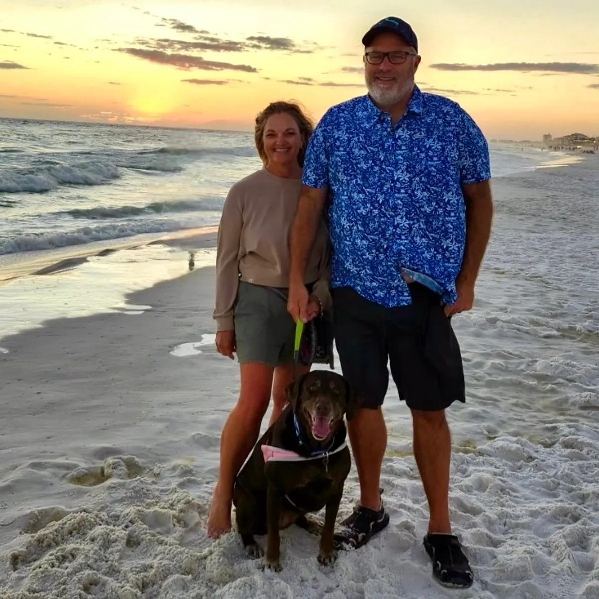Bret and Jennifer Crook, the husband-and-wife team behind Salty Crook Charters, walking their dog on the Destin shoreline